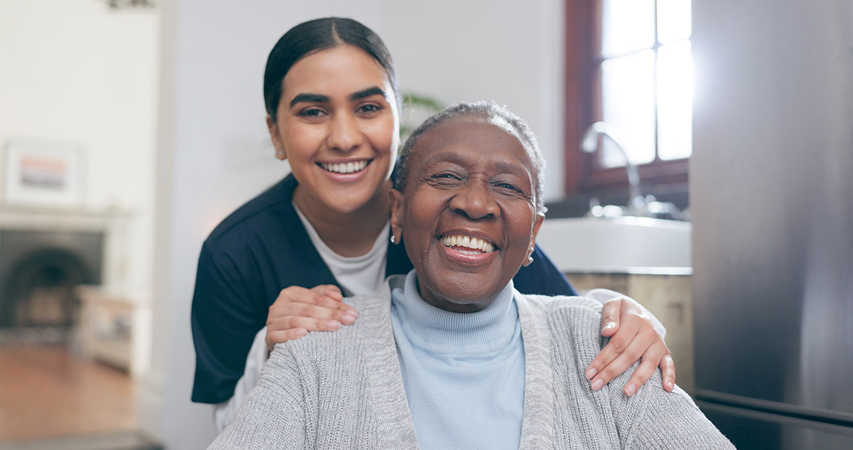 Smile, healthcare and portrait of nurse with patient in a wheelchair for discussion at nursing home. Medical career, happy and young female caregiver with senior black woman with disability in house
